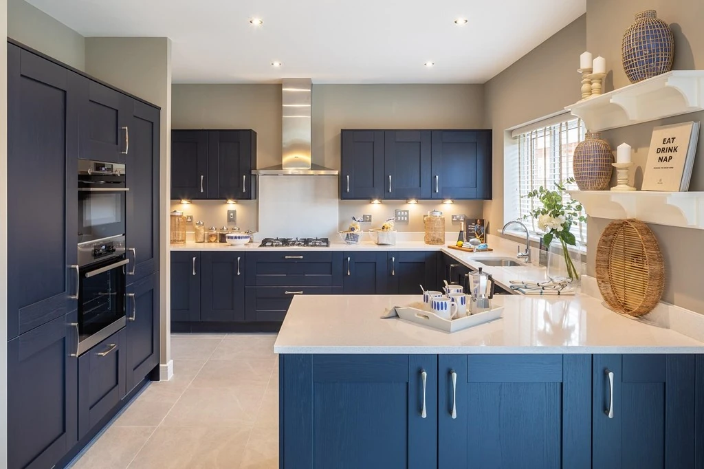 A modern kitchen with fitted appliances and blue cupboards