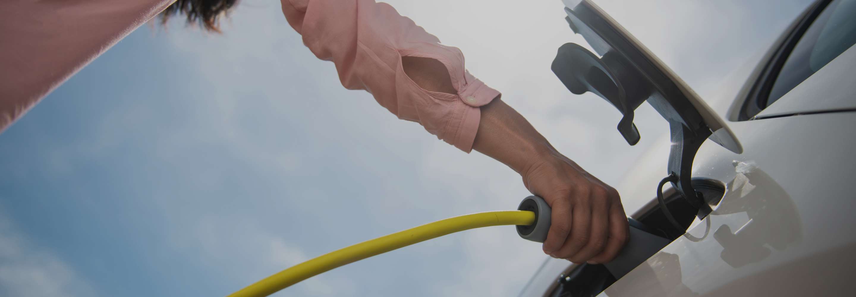 a person connecting a charger to an electric car
